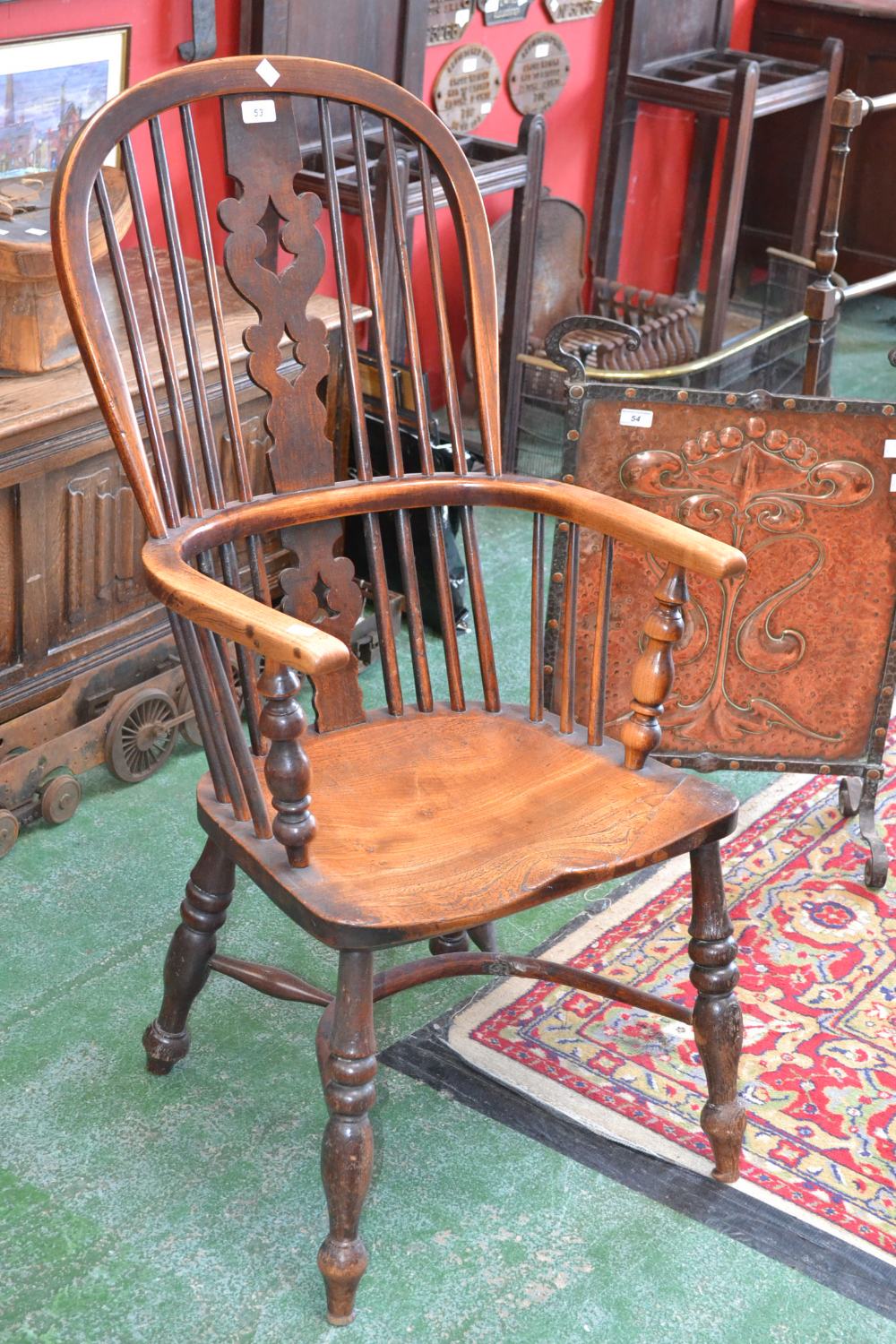 An elm windsor chair, hoop back, pierced splat, turned supports, crinoline stretcher