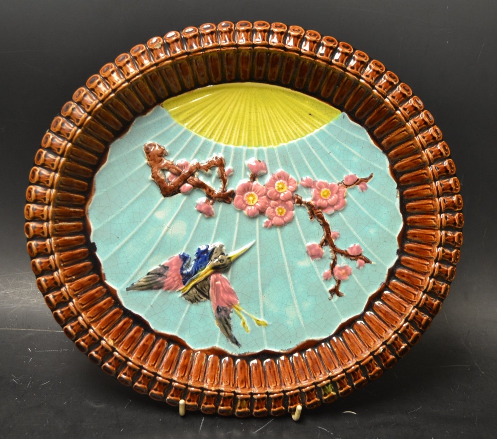 A 19th century Aesthetic Movement majolica oval dish, moulded in relief with a crane in flight and