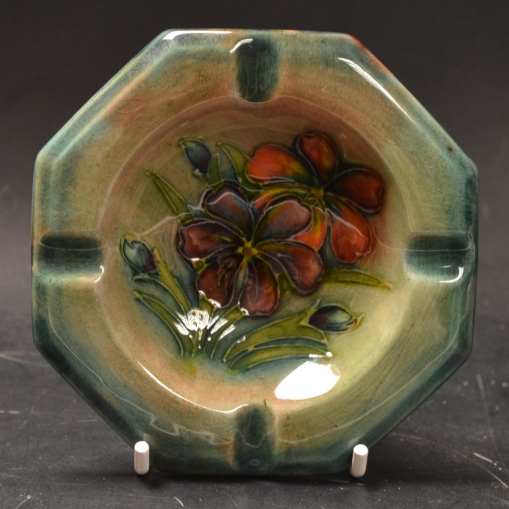 A Moorcroft ashtray, tubelined with flowers, green ground, impressed marks, 8cm diam