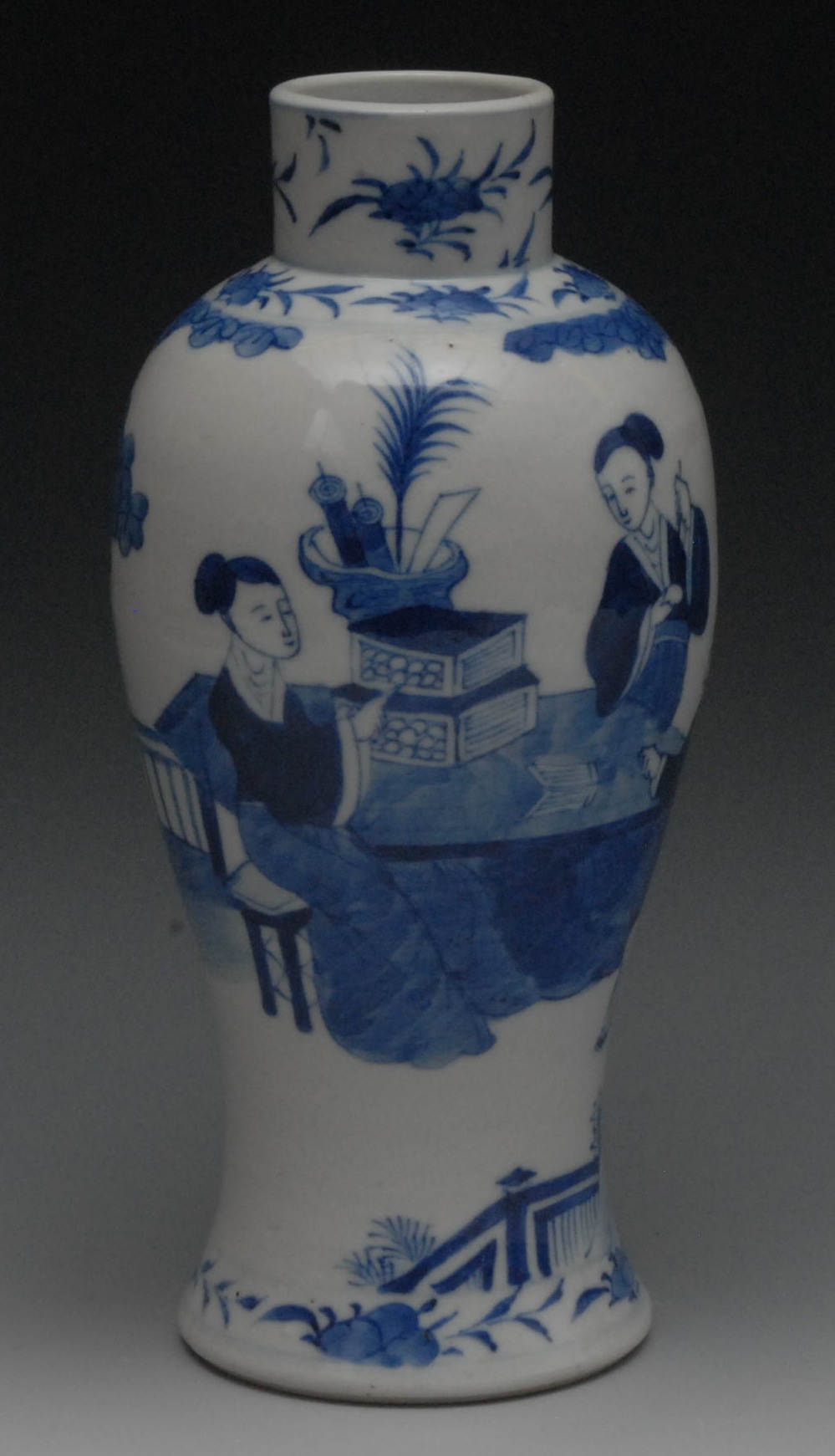 A Chinese porcelain slender baluster vase, painted in underglaze blue with figures at a table