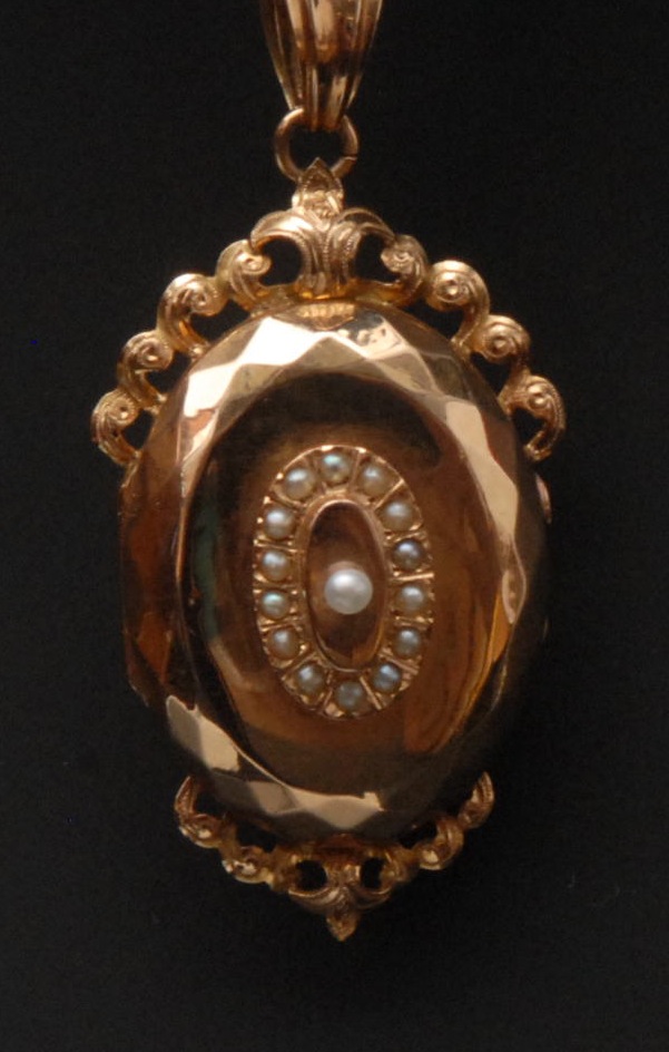 A 19th century French locket pendant,stepped oval body, raised central seed pearl, scrolling wave