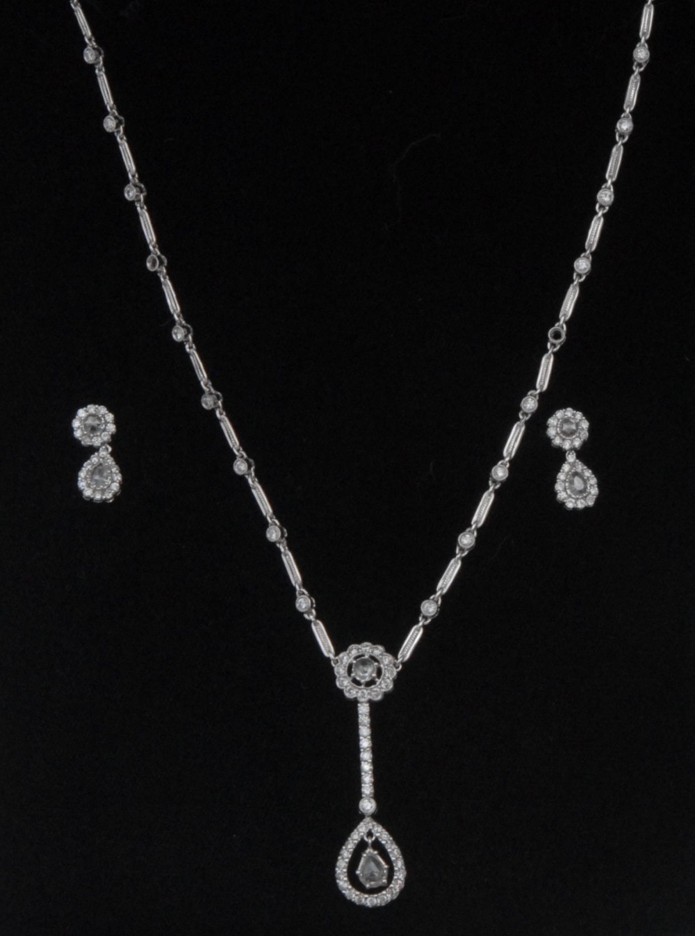 An impressive diamond pendant necklace and earring suite, the pendant necklace with tear drop