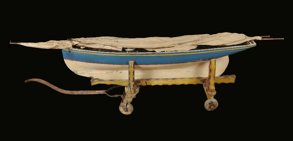 An unusually large scratch built model yacht, 174cm long, wooden trolley, brightly painted in