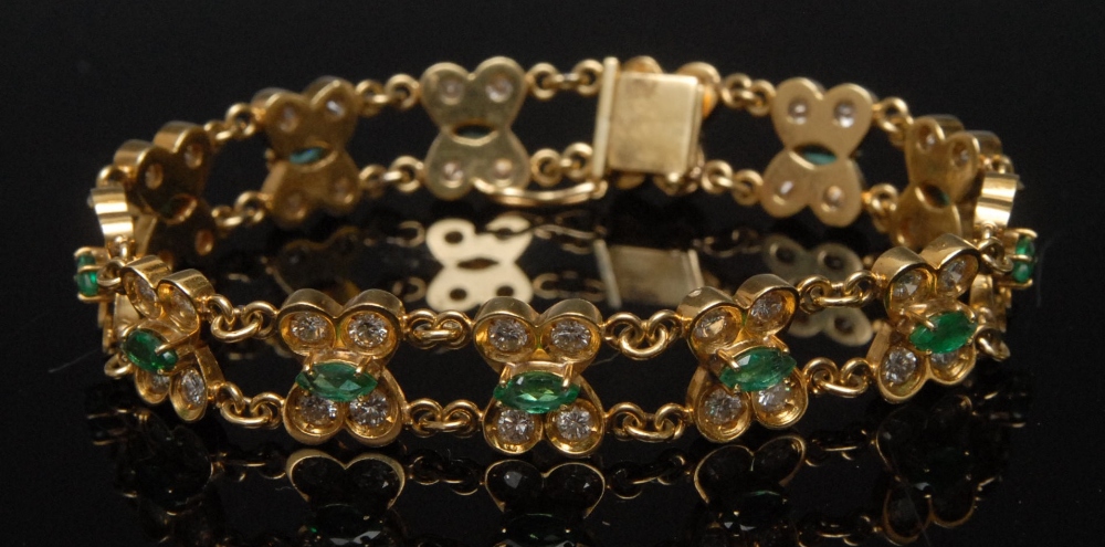 A diamond and emerald bracelet, the thirteen flower head links, each with a central oval emerald,