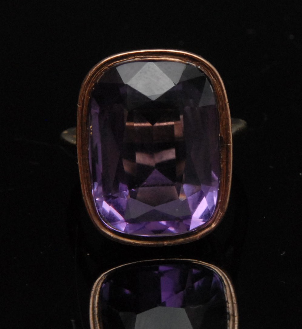 A large amethyst solitaire ring, approx. 17.31ct, repousse floral collar, 9ct rose gold shank,