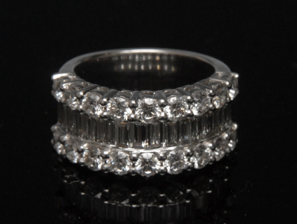 A diamond half hoop cluster ring, central row of eighteen baguette diamonds, flanked by two rows