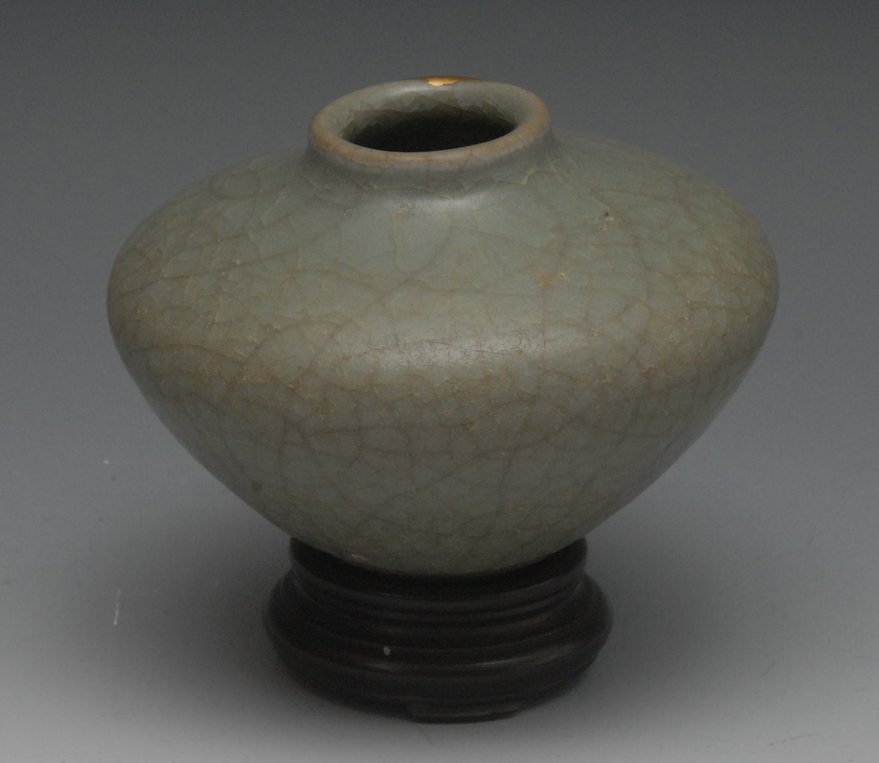 A Chinese celedon globular vase, crackle glaze, 7.5cm high, hardwood stand