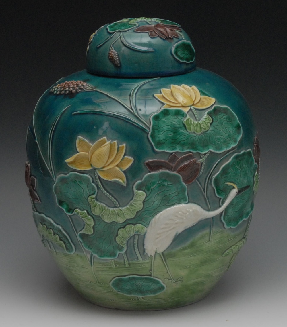 A Chinese ovoid ginger jar and cover, decorated in high relief with a crane amongst water lilies,