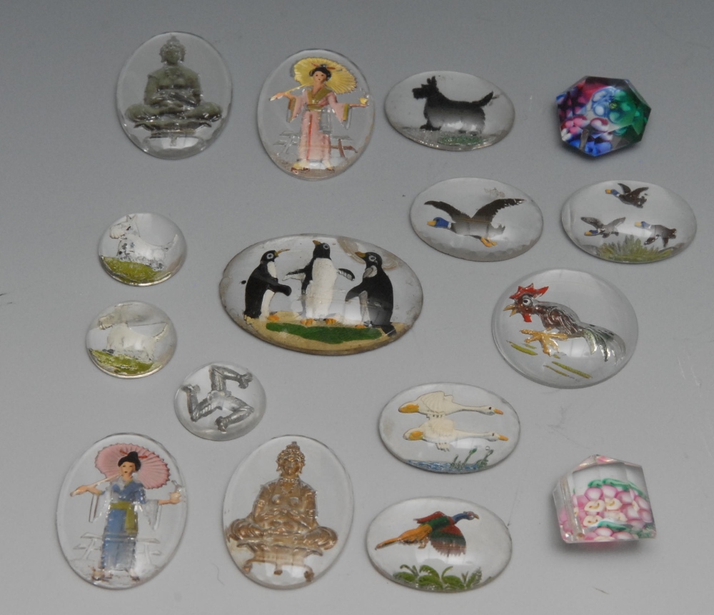 A collection of sixteen reverse painted intaglio crystals, various  subjects including three