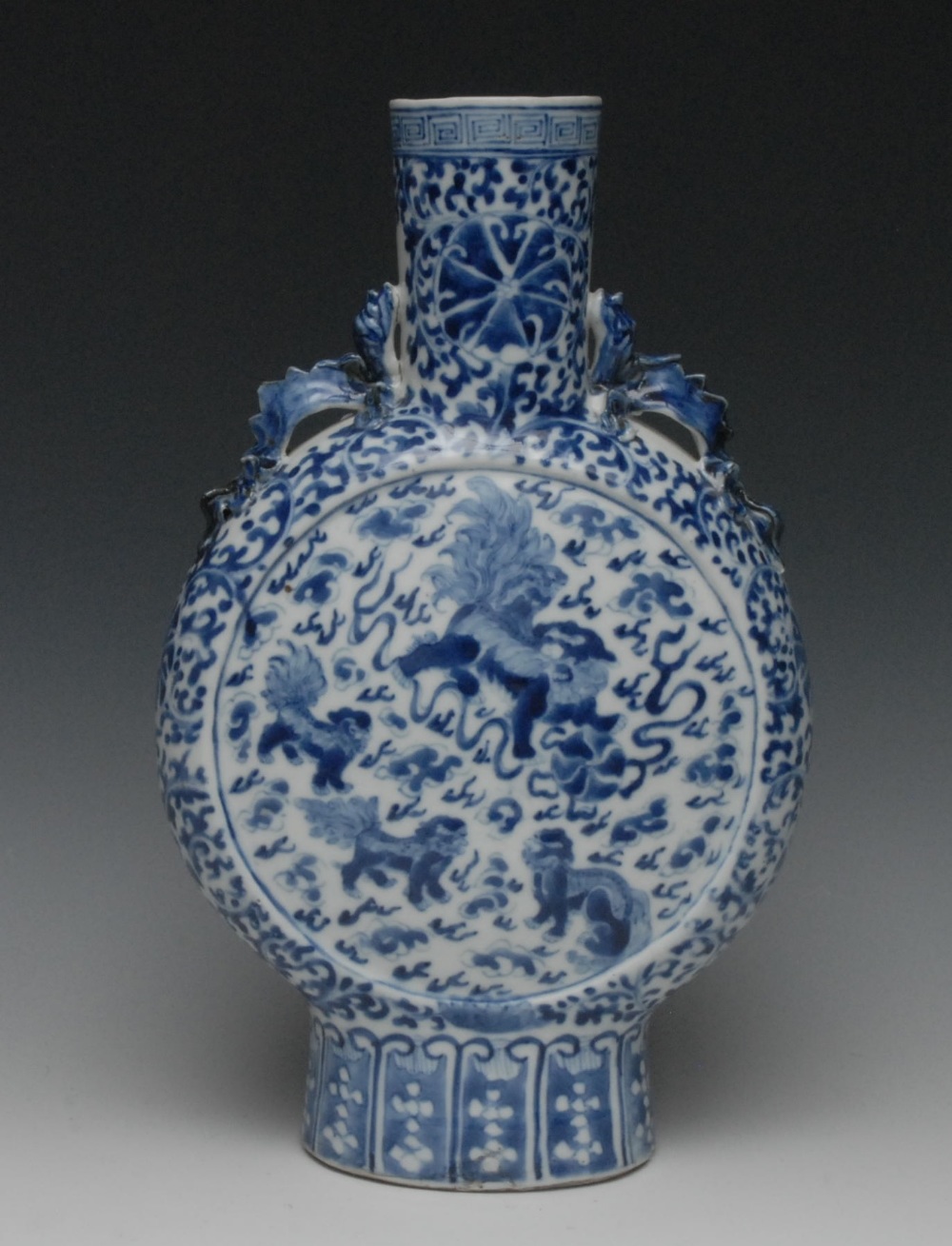 A Chinese porcelain moon flask, painted in underglaze blue with temple lions and scrolls, dragon