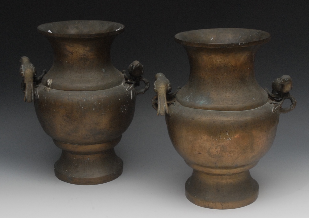 A pair of Chinese bronze vases, engraved overall with peonies and scrolls, bird and bamboo