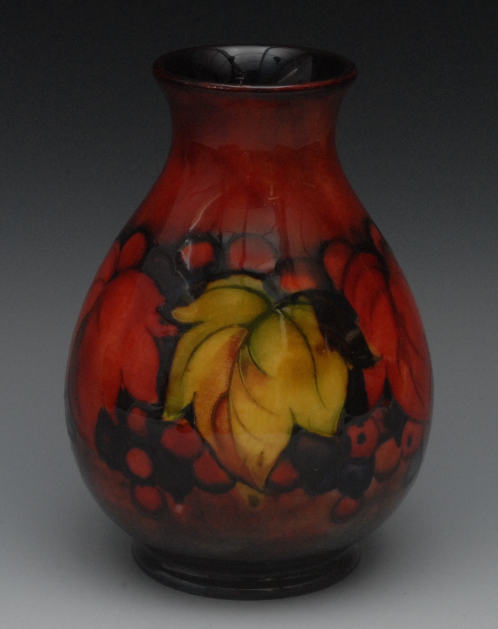 A Moorcroft Flambe Leaf and Berry pattern baluster vase, tube lined with large leaves and berries,