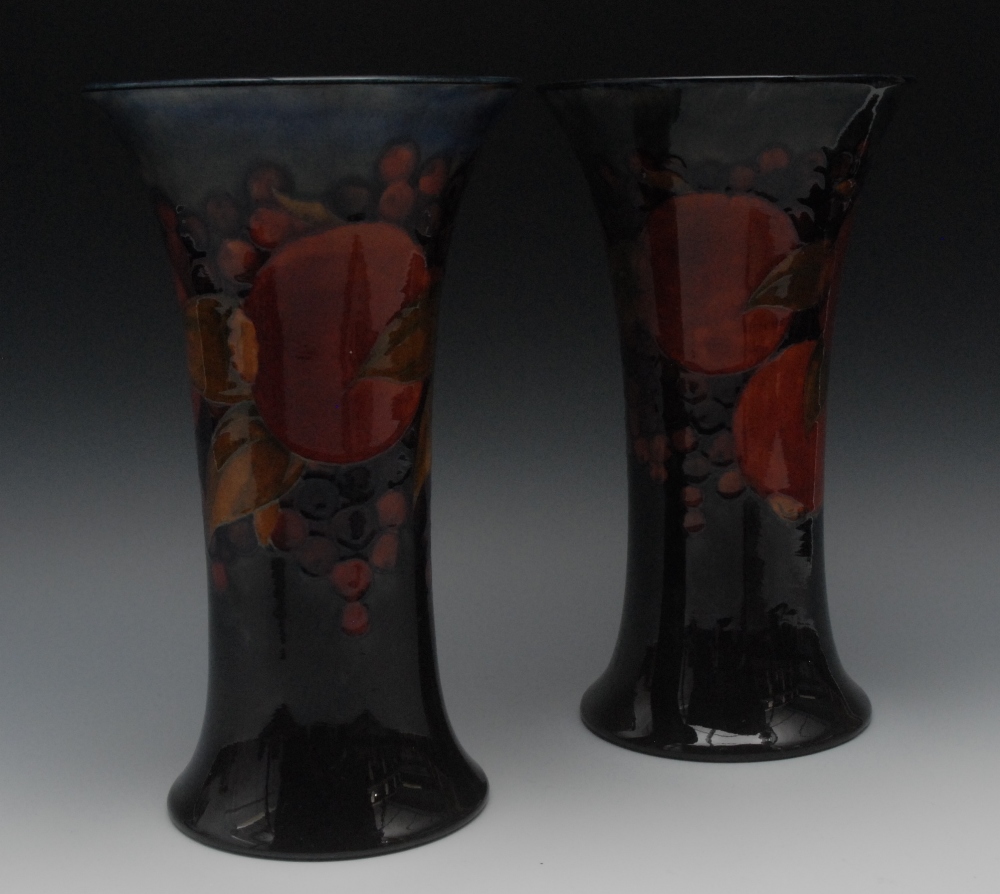 A pair of Moorcroft Pomegranate pattern flared cylindrical vases, tube lined with fruit and berries,