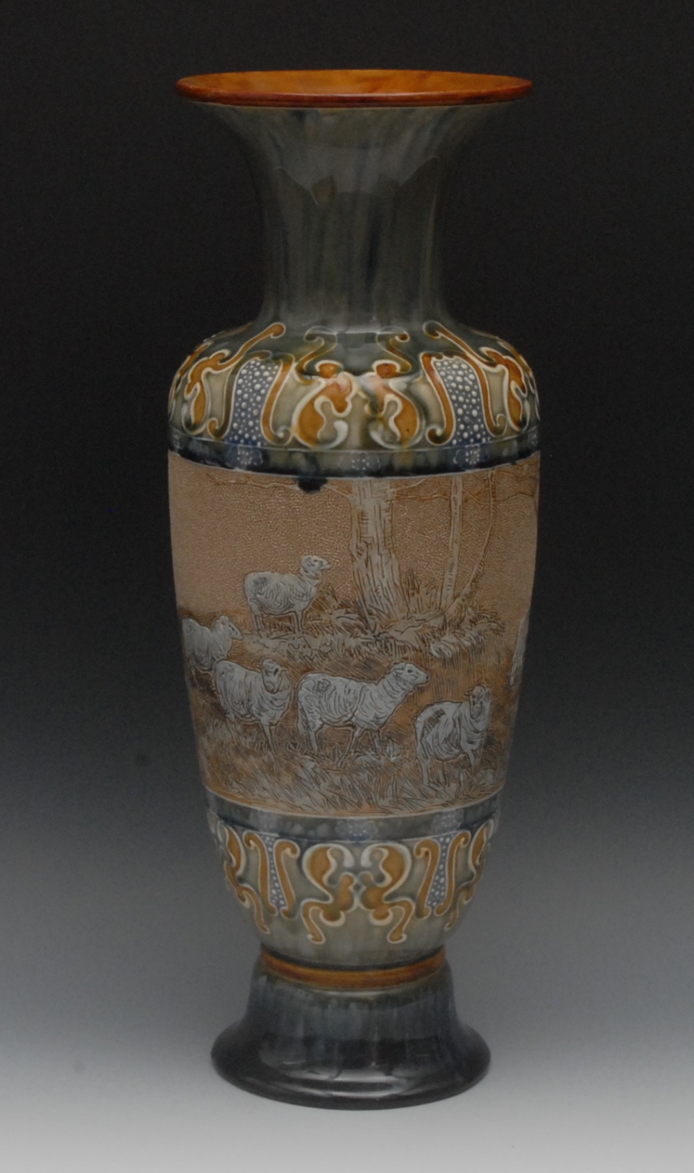 A Doulton Lambeth slender ovoid vase, incised with a continuous band of sheep grazing on a