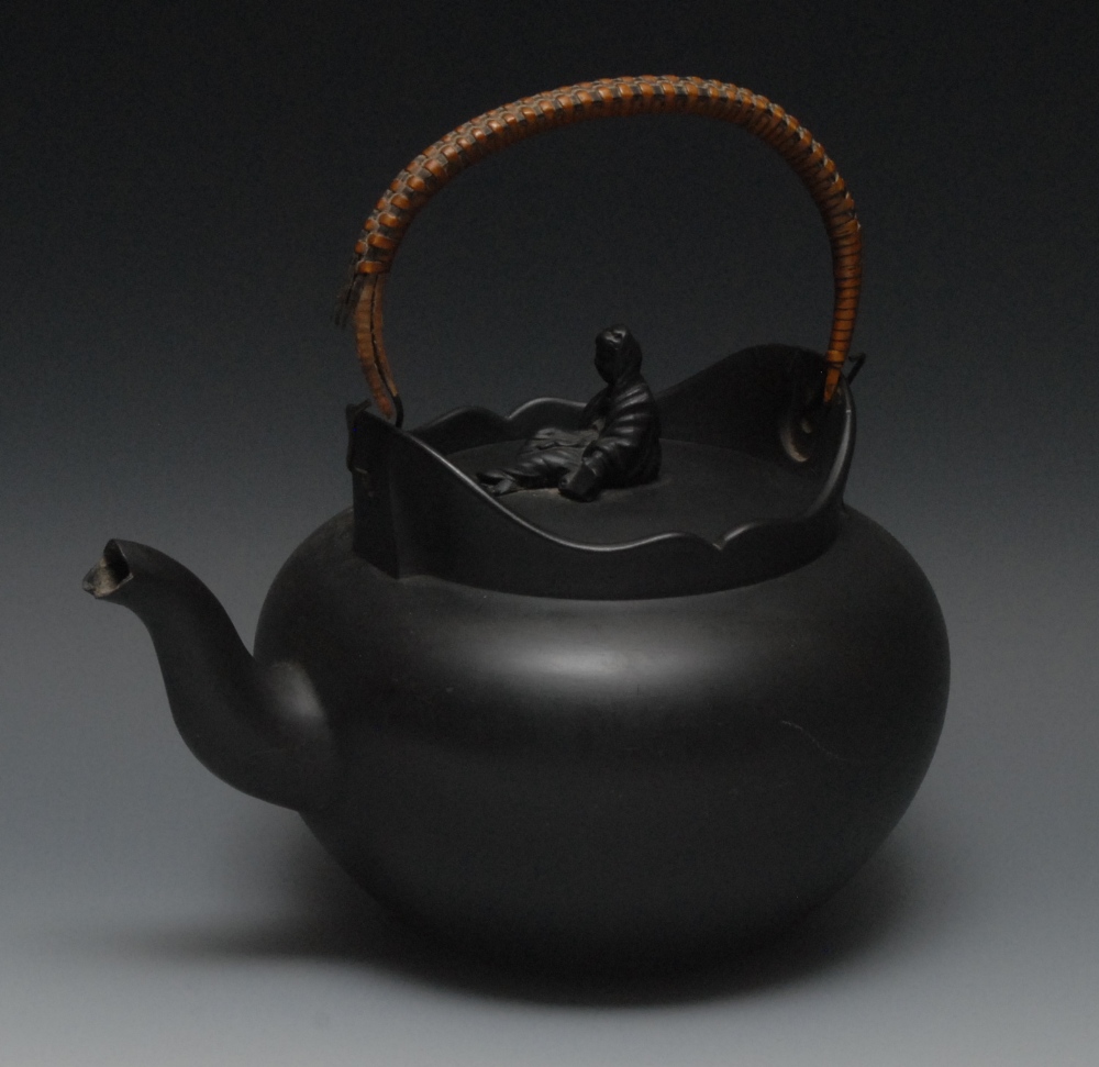 A Wedgwood black basalt  globular tea kettle, undulating rim, weeping widow finial, wicker handle,