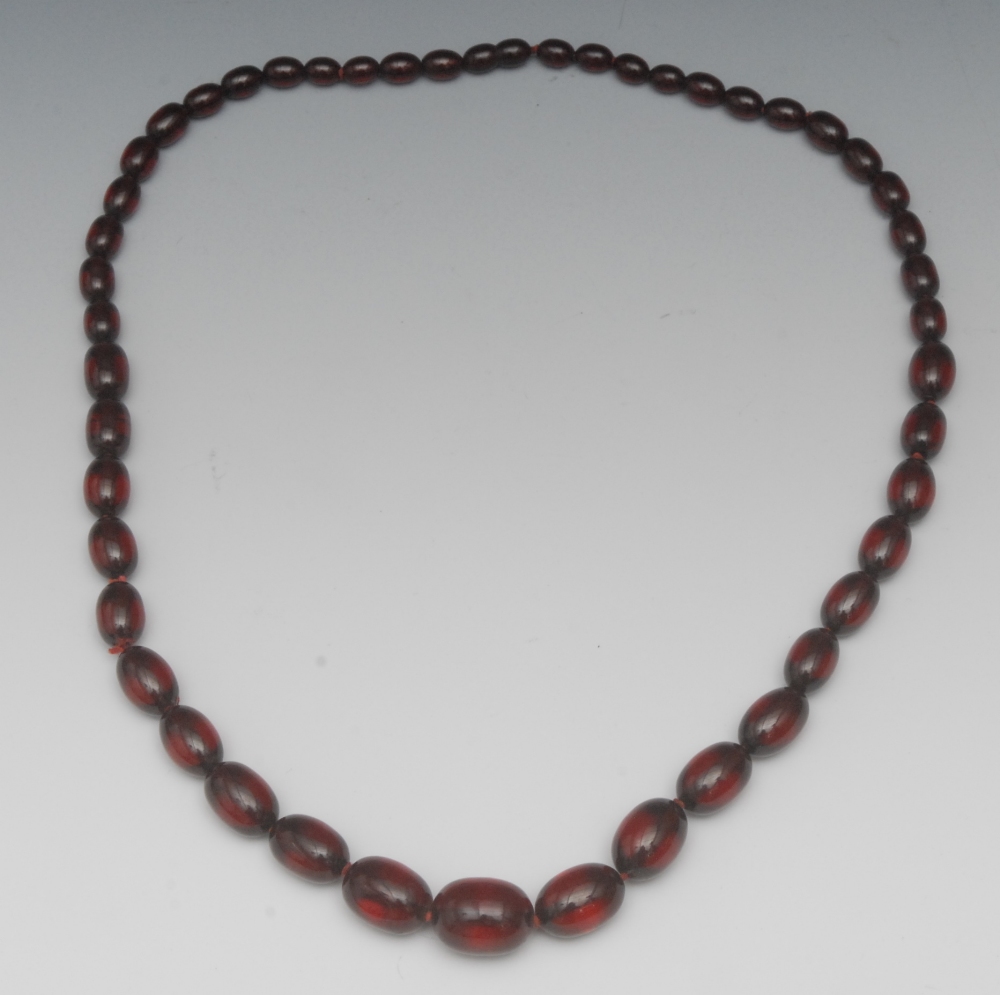 A single strand cherry amber bead necklace, of forty-nine graduated beads, 68cm long 61g