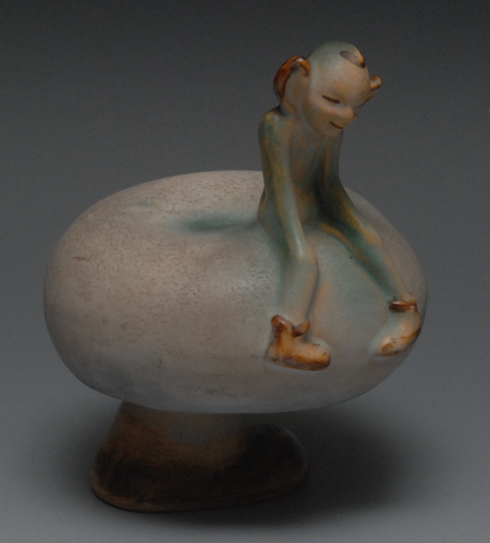 An unusual Bourne Denby model of an impish pixie seated upon the edge of a toadstool, glazed in