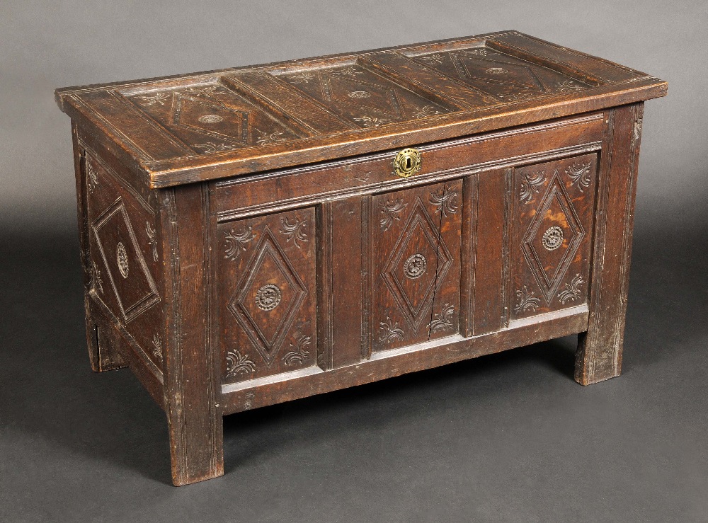 A 17th century oak three-panel blanket chest, hinged top and front carved with lozenges, stile feet,