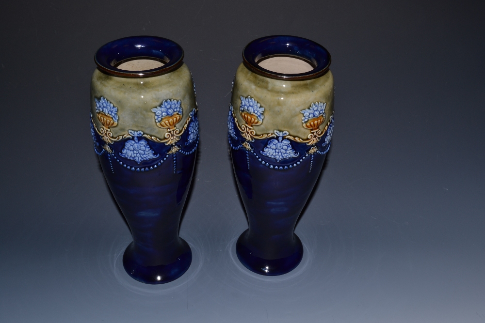 A pair of Doulton Lambeth slender ovoid vases, in relief with  garlands and bowls of fruit,