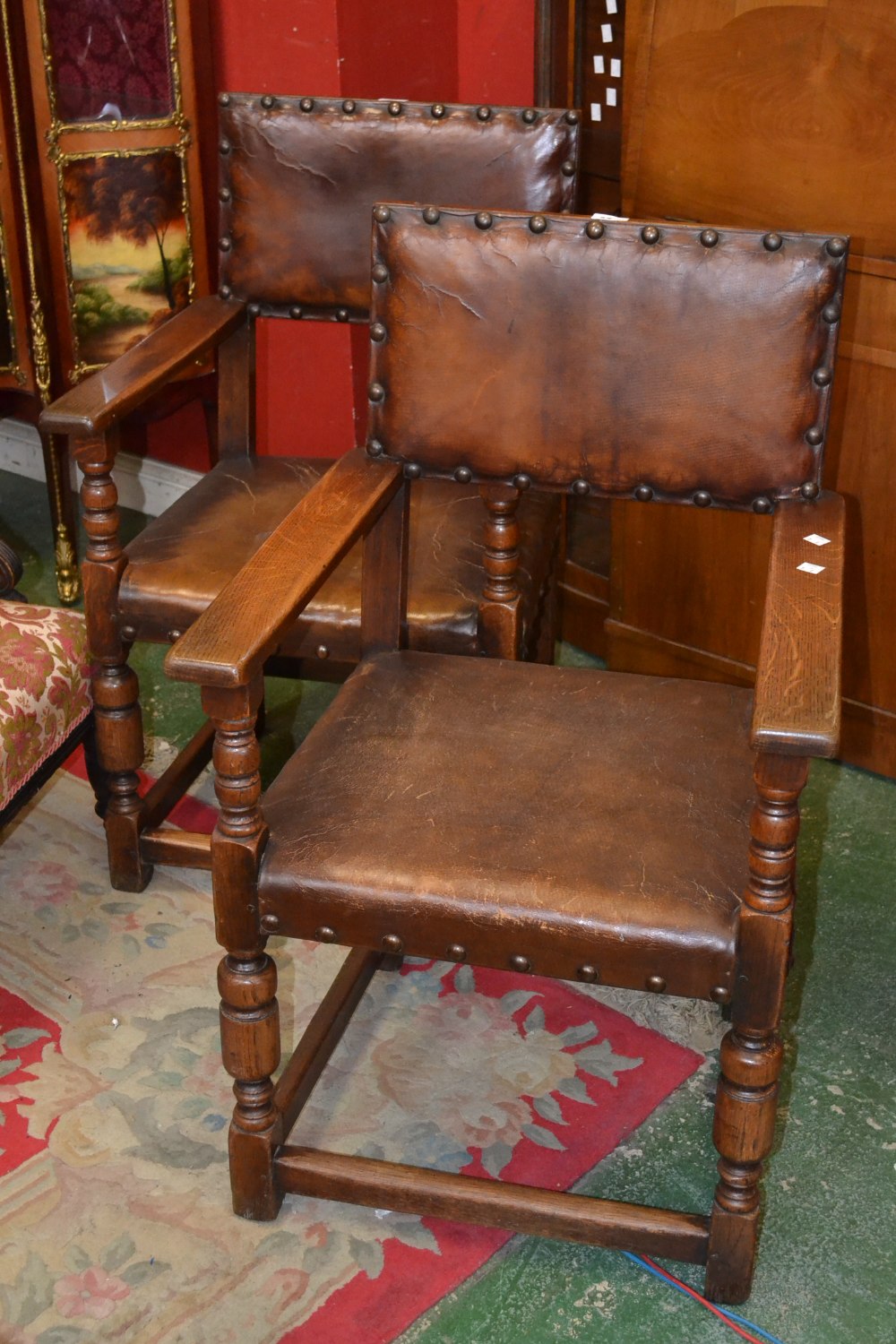 A pair of oak carver chairs, padded leather back and seat, turned forelegs
