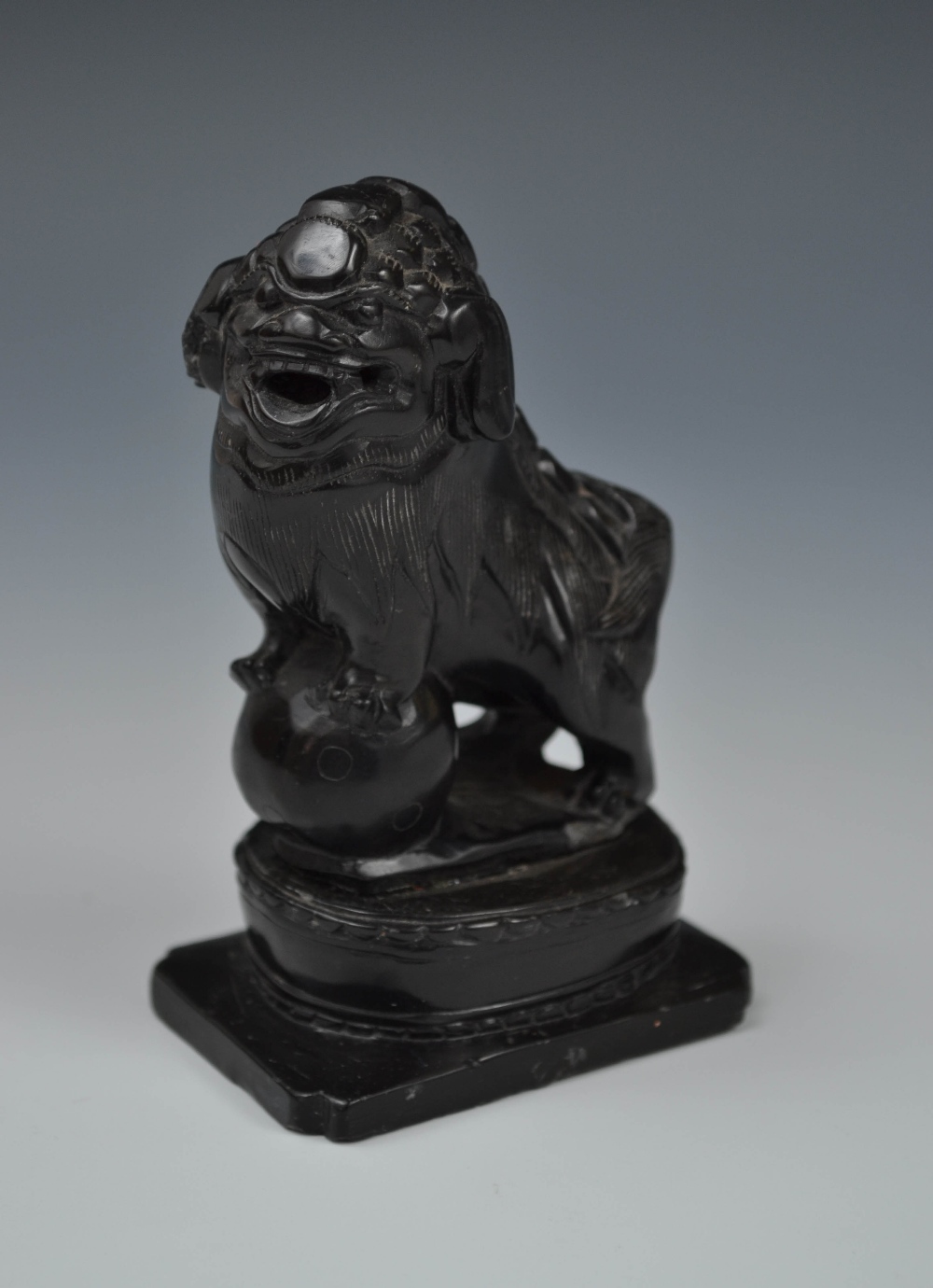 A Chinese hardstone carving of a Shisai dog mounting a sphere, 9cm high