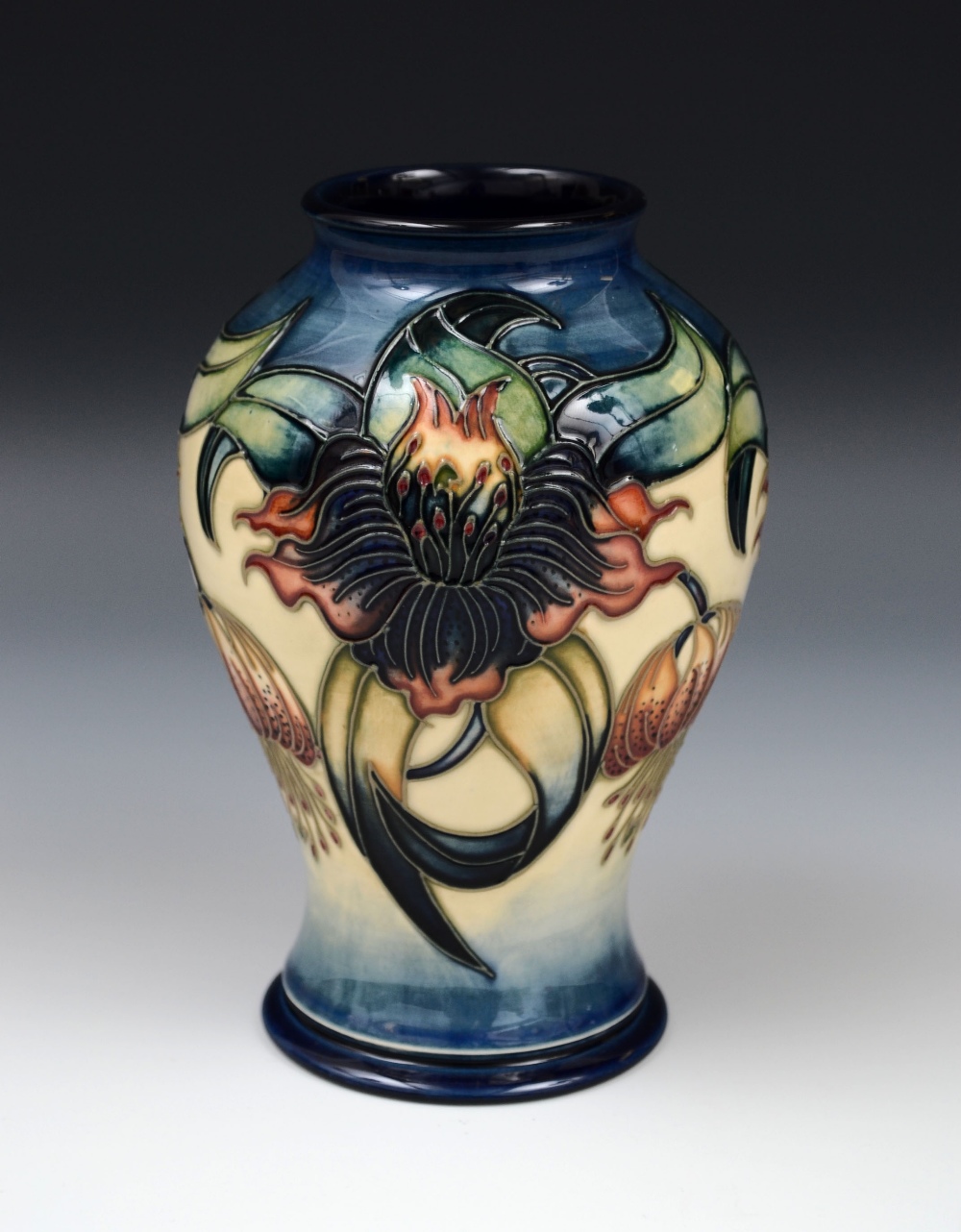 A contemporary Moorcroft baluster trial vase, tubelined with stylised orchids and coloured in