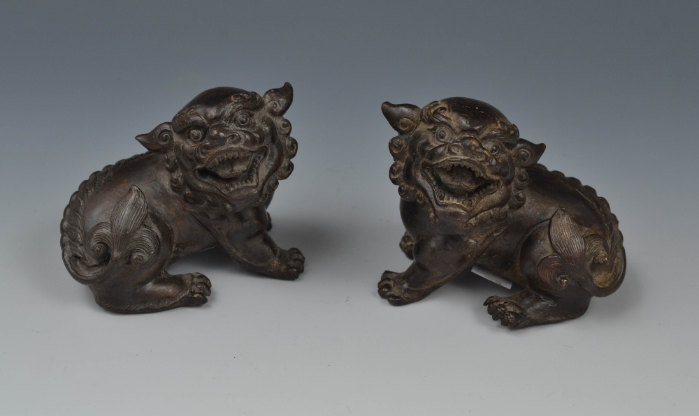 Chinese School, a pair of dark patinated bronzes, of temple lions, seated to left and right, 8cm
