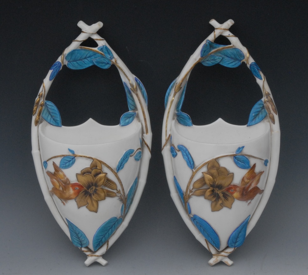 A pair of George Jones wall pockets, in relief with humming bird and honeysuckle in gilt and