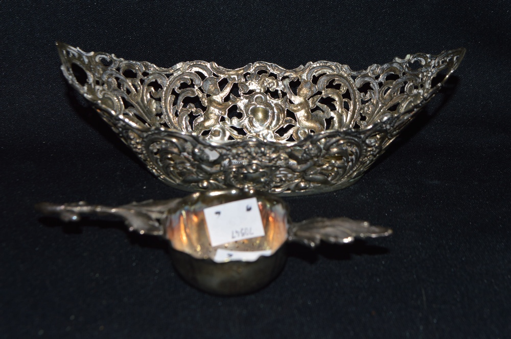 A continental silver basket; a silver coloured  tea strainer (2)