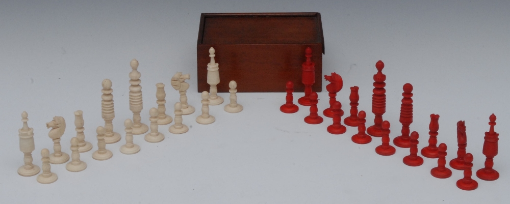 A 19th century English bone chess set, red stained opposition, the kings 9cm high, mahogany box