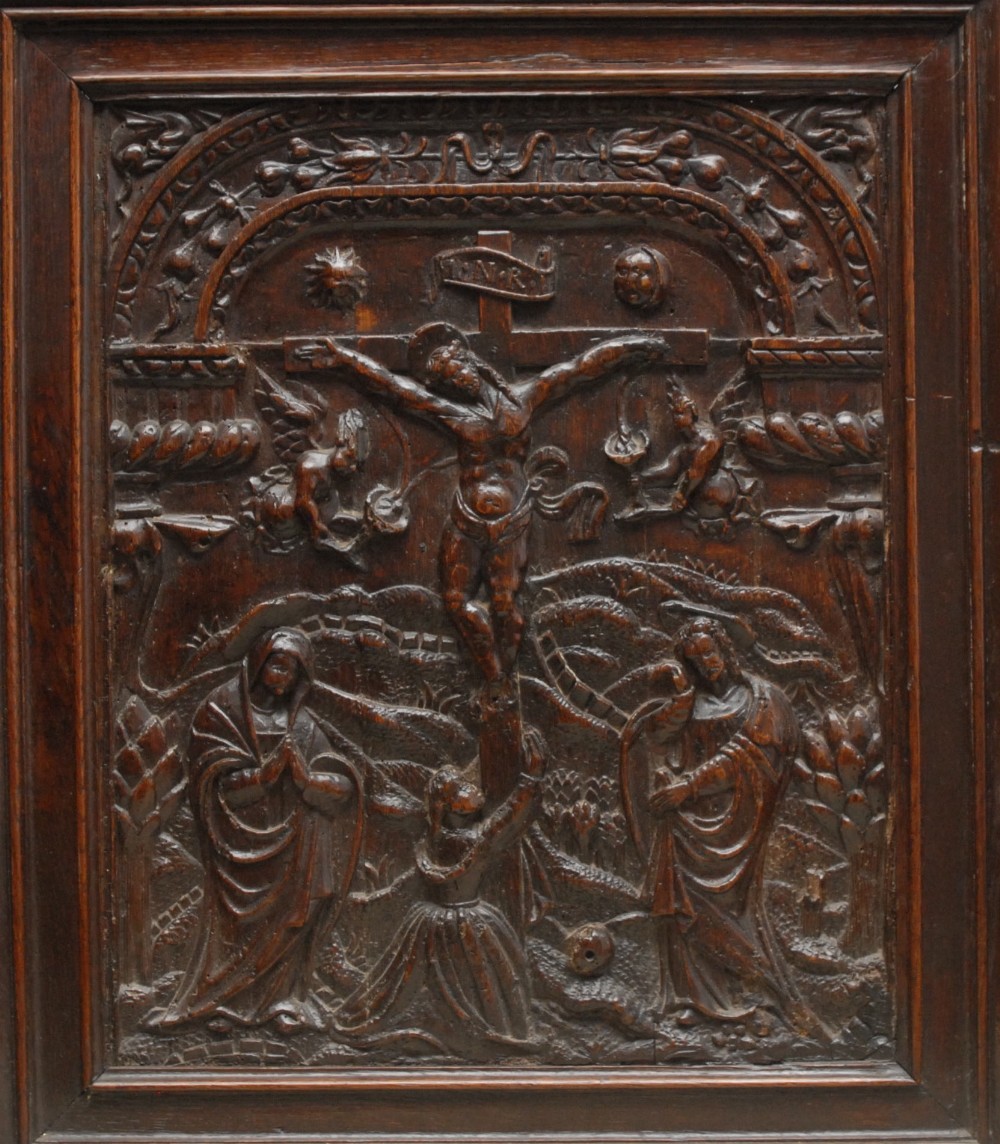 A 17th century oak rectangular panel, carved in relief with The Crucifixtion, 54cm x 44cm, c.1650 -