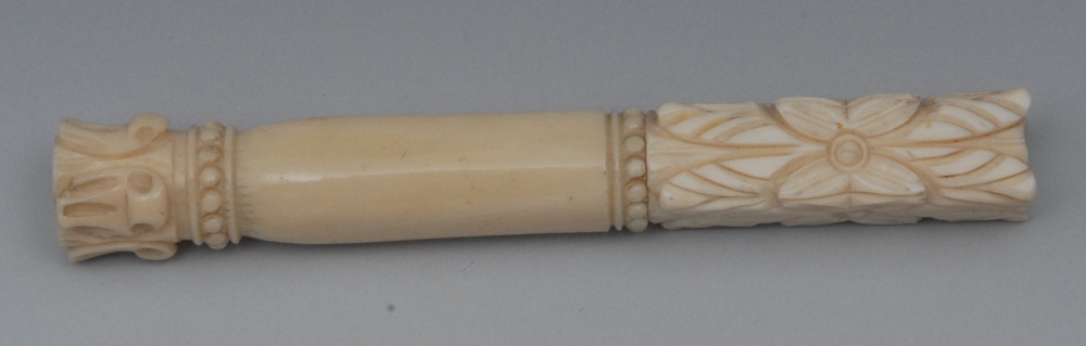A French ivory bodkin case, the base and screw-fitting cover carved with lotus, beaded girdles,
