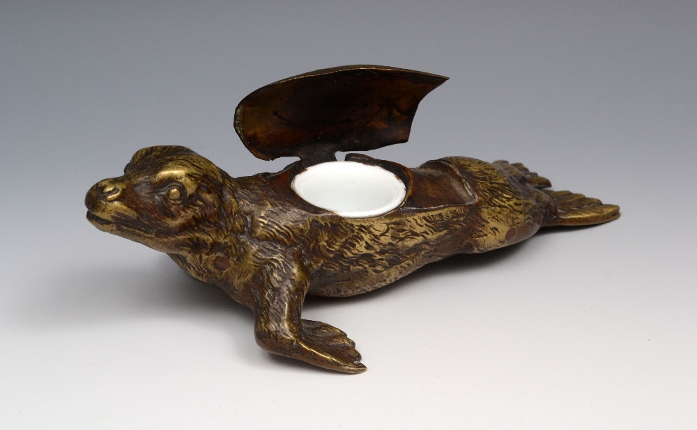 A 19th century bronze novelty inkwell, naturalistically cast as a seal, his back hinged as a cover,