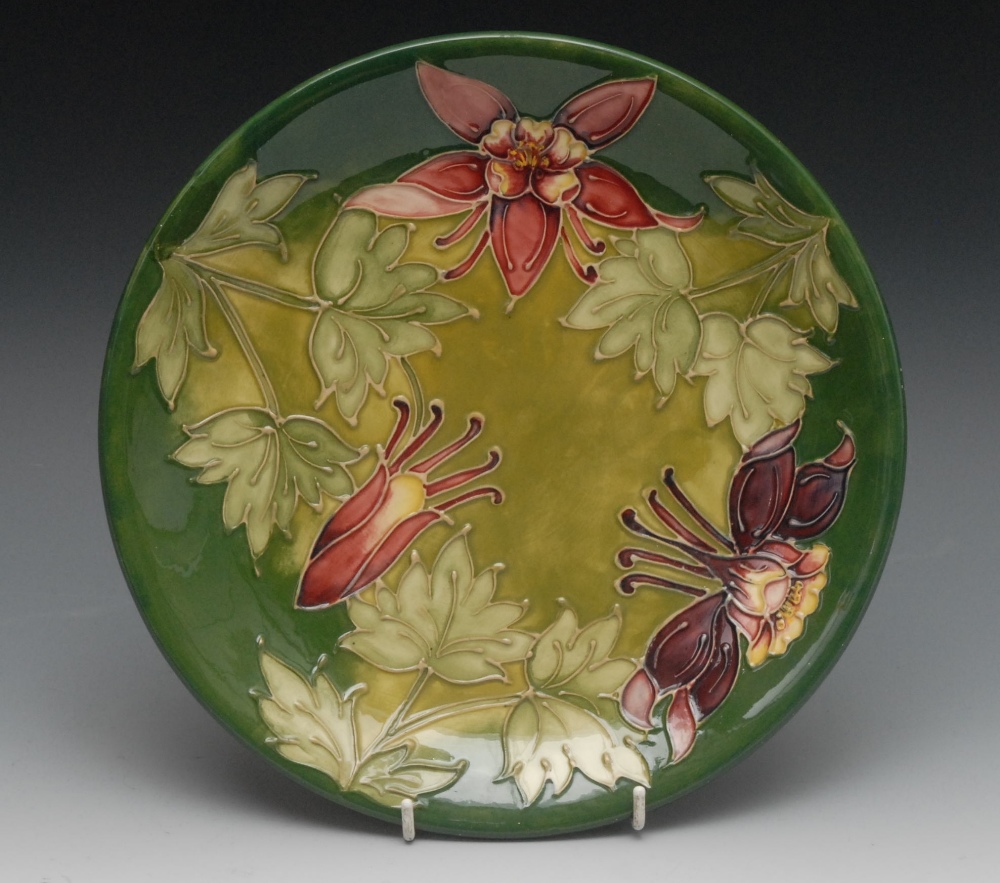 A Moorcroft Honeysuckle pattern plate, tube lined with large flowers and foliage, on a green