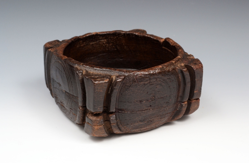 A 17th century oak offertory or sanctuary bowl, projecting angles, carved with arcs and inscribed