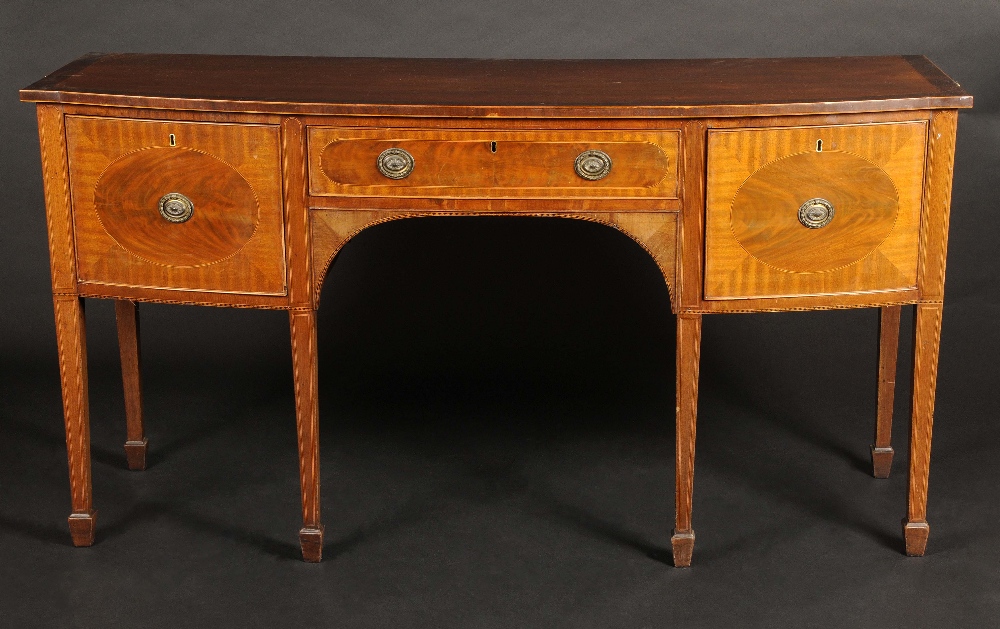 A 19th century crossbanded mahogany bow fronted sideboard, oversailing top above an arrangement of