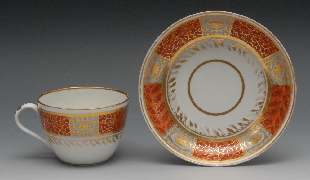 A Pinxton Bute shape teacup and saucer, pattern no. 367, enamelled and gilt with oval paterae,