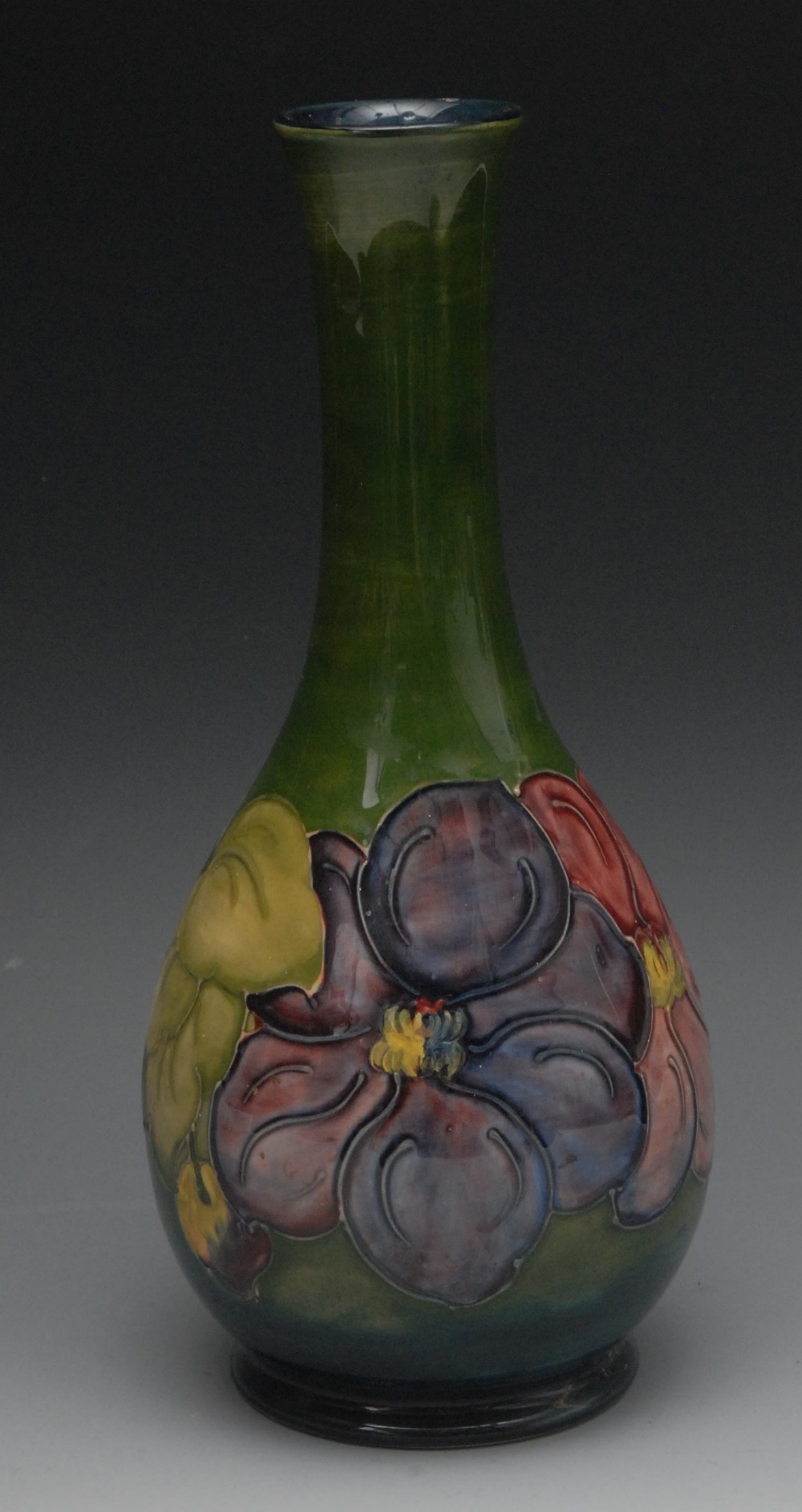 A Moorcroft Hibiscus pattern bottle vase, tube lined with large flowers and foliage, on a green