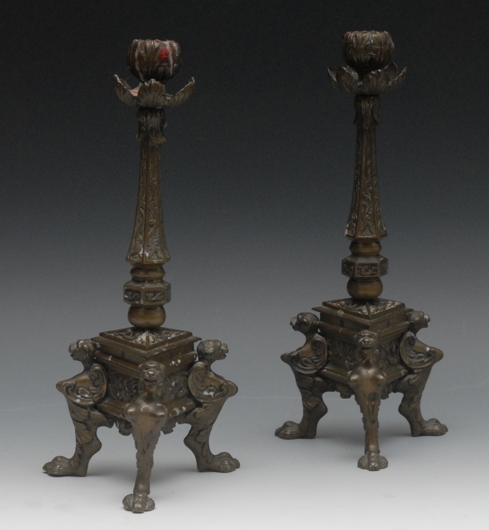 A pair of late 19th century French bronze table candlesticks, leafy sconces and nozzles, spreading