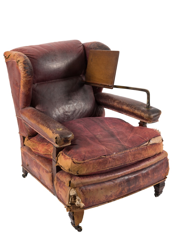 An Edwardian mahogany wing frame library armchair:, upholstered in crimson leather and with loose