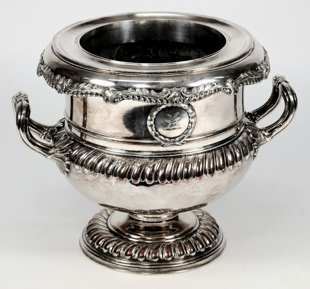 A Sheffield plate wine cooler: crested, of neo-classical urn shaped outline, with gadrooned rim