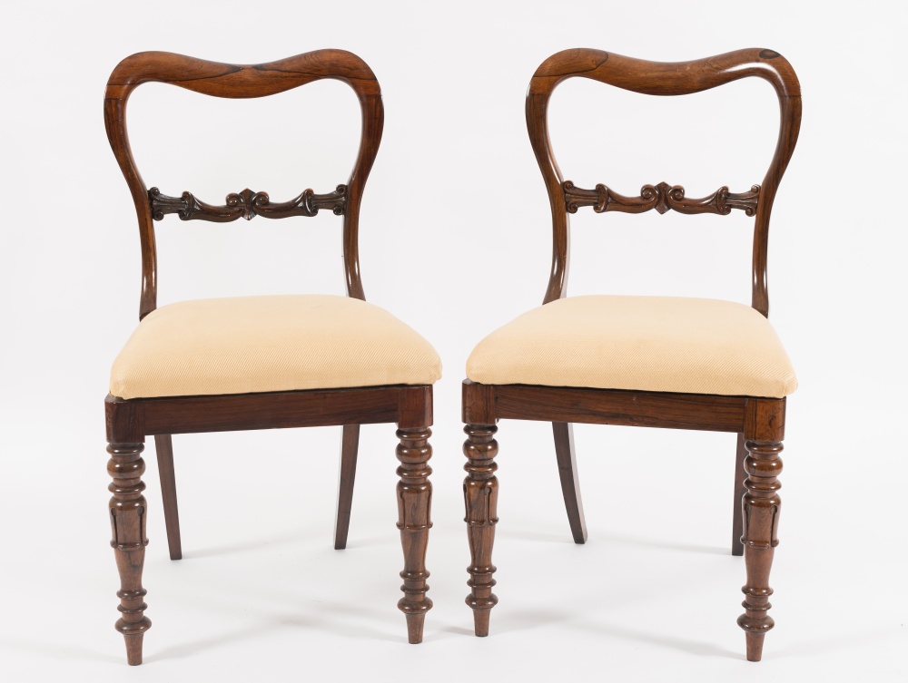 A set of six Victorian carved rosewood dining chairs:, the cartouche shaped open backs with