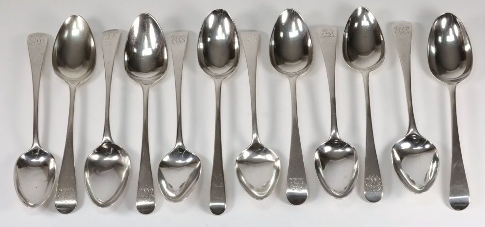 A collection of twelve Georgian silver fiddle pattern dessert spoons: monogrammed or crested,