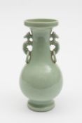 A Chinese celadon glazed baluster vase: with pierced dragon handles with attached rings, the