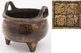 A Chinese bronze tripod censer: with loop carrying handles to the rim and bears four character mark