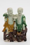 A Chinese biscuit porcelain figure group of Hehe and Erxian: each standing on pierced rocks strewn