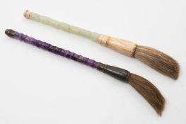 A Chinese jade mounted artist`s brush and a similar amethyst mounted brush: the first carved with