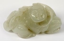 A Chinese jade carving of Liu Hai; leaning over on his three-legged toad and holding a string of