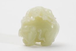 A Chinese celadon jade carving: of a man riding on the back of an elephant and holding a lingzhi
