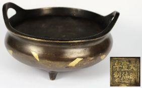 A Chinese bronze tripod circular censer: inset with geometric motifs and having loop carrying